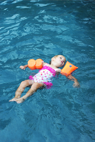 Young girl floating in pool