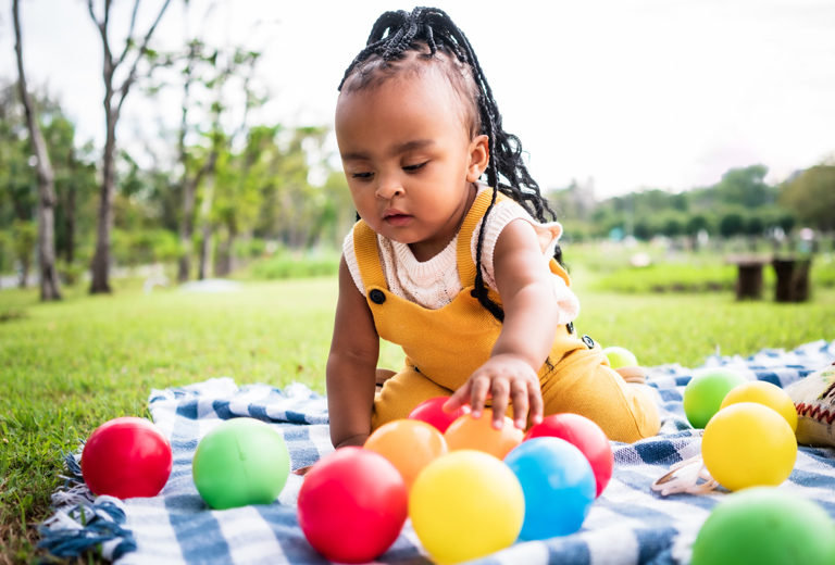 little girl playing with toy balls