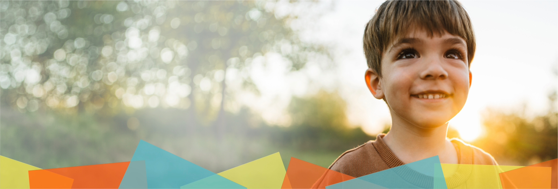 Boy smiling in front of sunset