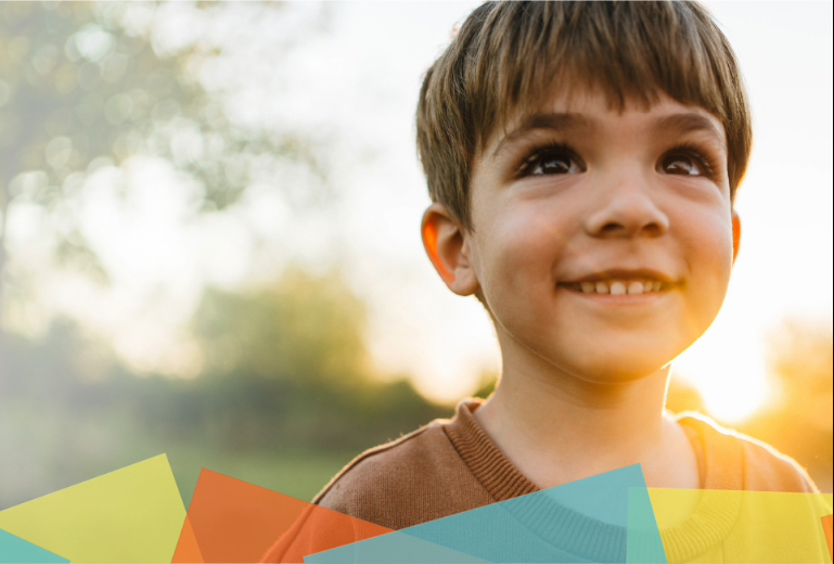 Boy smiling in front of sunset