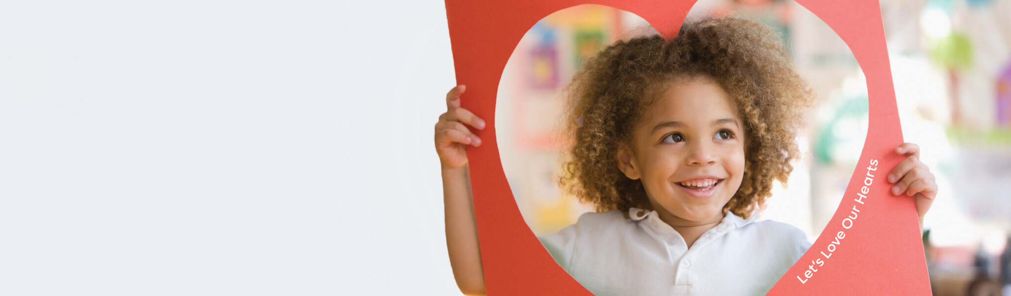 Little Girl standing behind a heart cutout