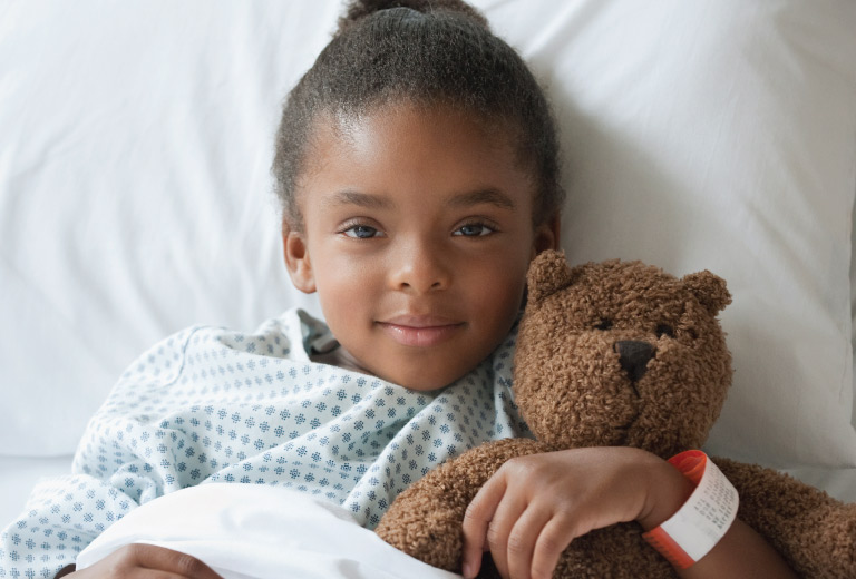 March is Child Life Month - Toddler Girl holding a teddybear.