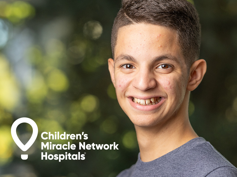 Boy smiling next to text saying 'Children's Miracle Network Hospitals'