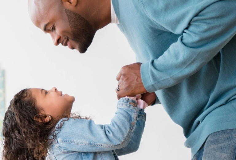 Father and daughter smiling at eachother