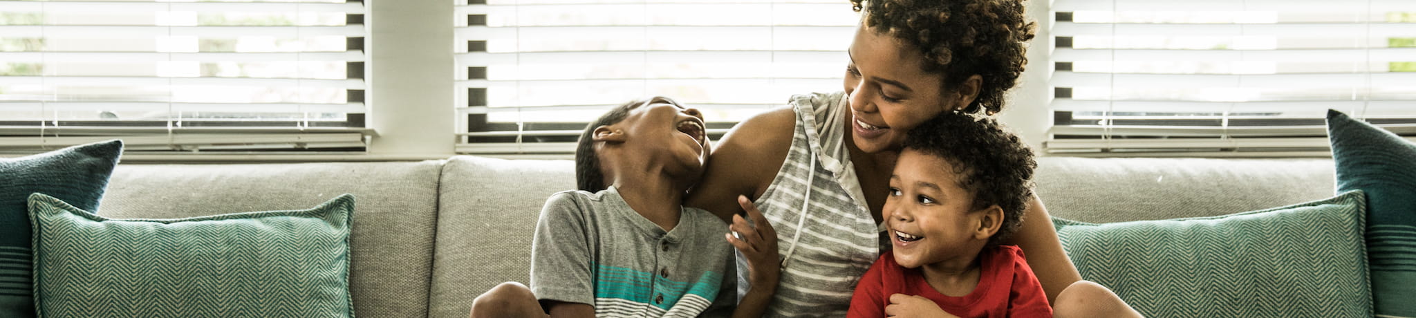 Genetics - Family of three on couch laughing