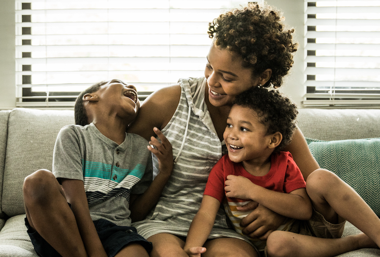 Genetics - Family of three on couch laughing