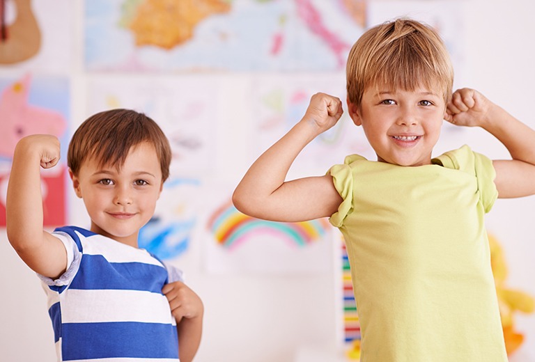 Two children flexing muscles