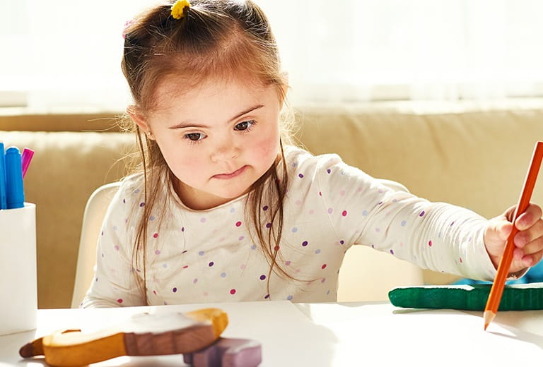 Girl drawing with colored pencil