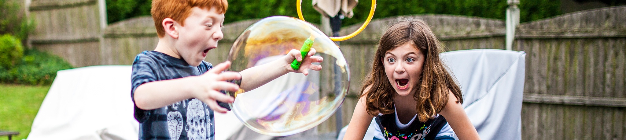 Two kids playing with large bubble