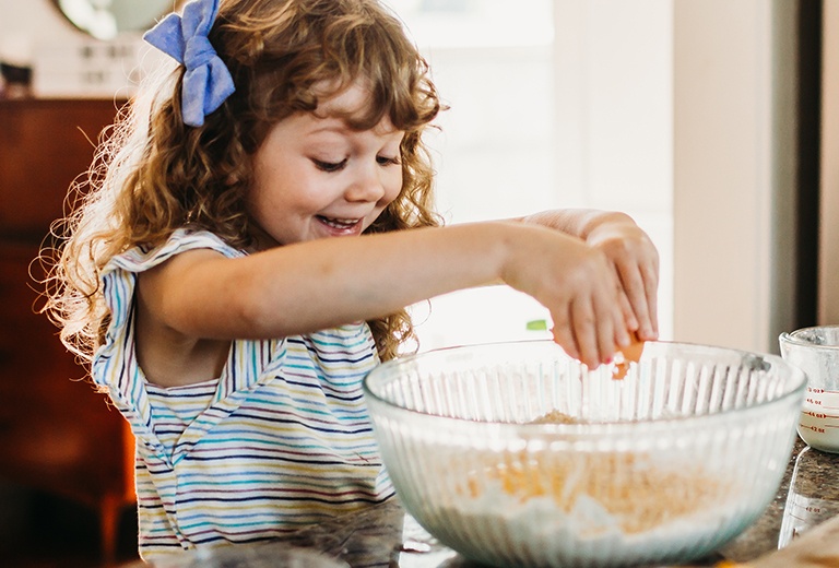 Girl mixing food in bowl with hands