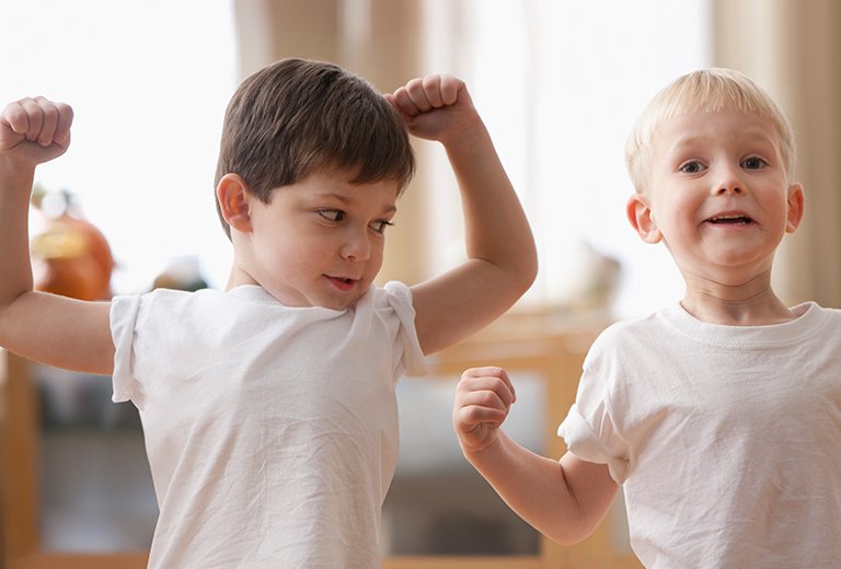 Two boys flexing muscles