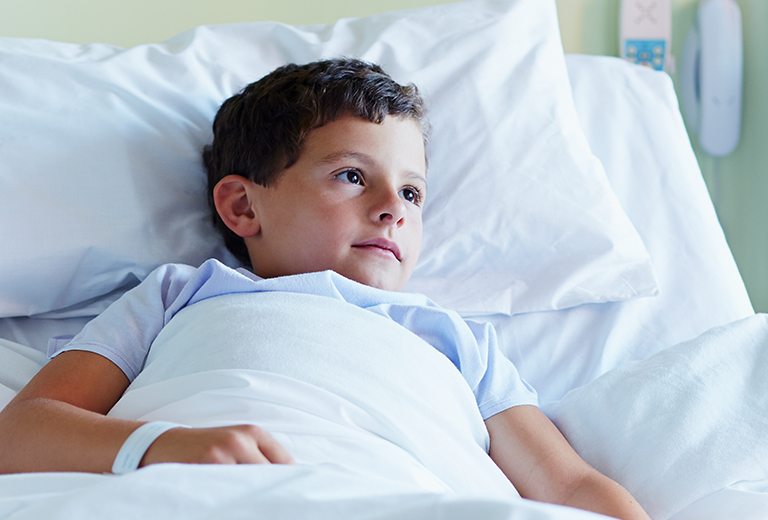Boy laying in hospital bed