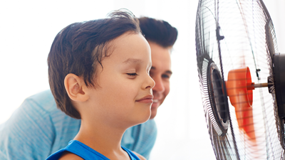 Boy being cooled by fan