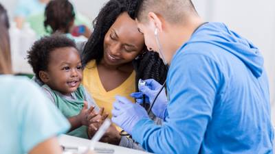 Doctor entertains a mother and her child as they wait for test results