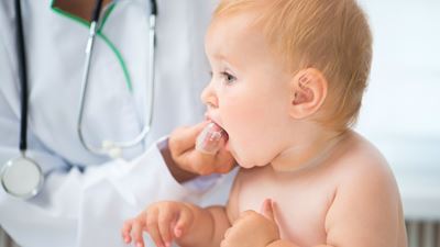 Doctor massaging babys gums