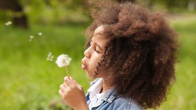 Girl blowing dandelion