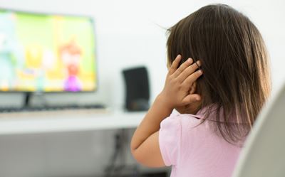 Little girl covering ear with hand