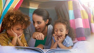 Mom and kids reading in pillow fort