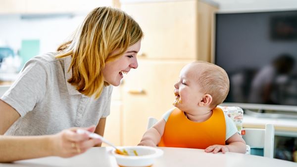 Mom feeding infant solid food