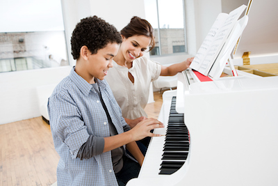Boy Playing Piano with Teacher
