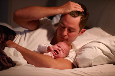 Father in Bed with Crying Baby