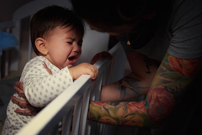 Mom Comforting Baby in Crib