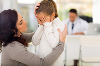 Mom Comforting Girl at Doctor's Office