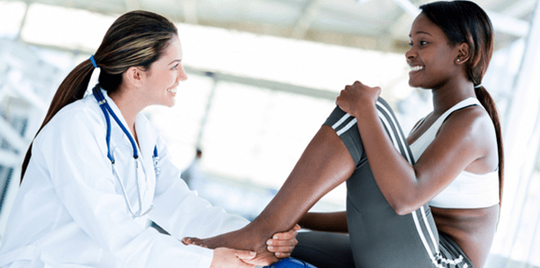 Physician taking a look at an athlete's ankle.