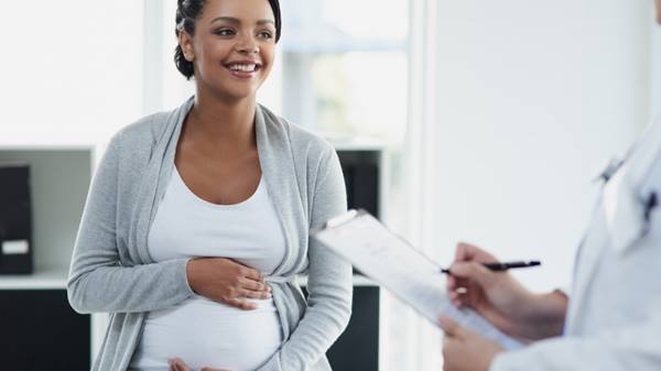 Pregnant woman speaks with doctor