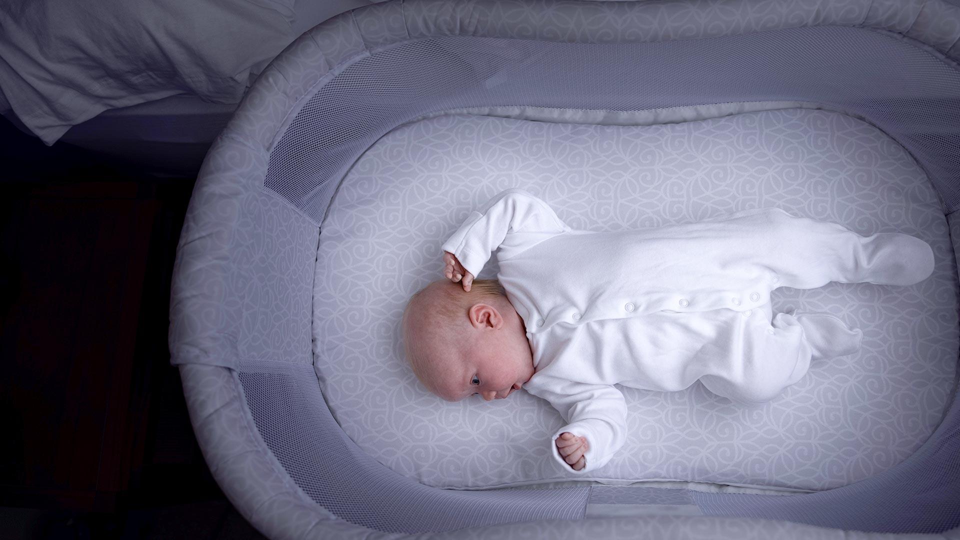 A baby laying in it's crib at night.