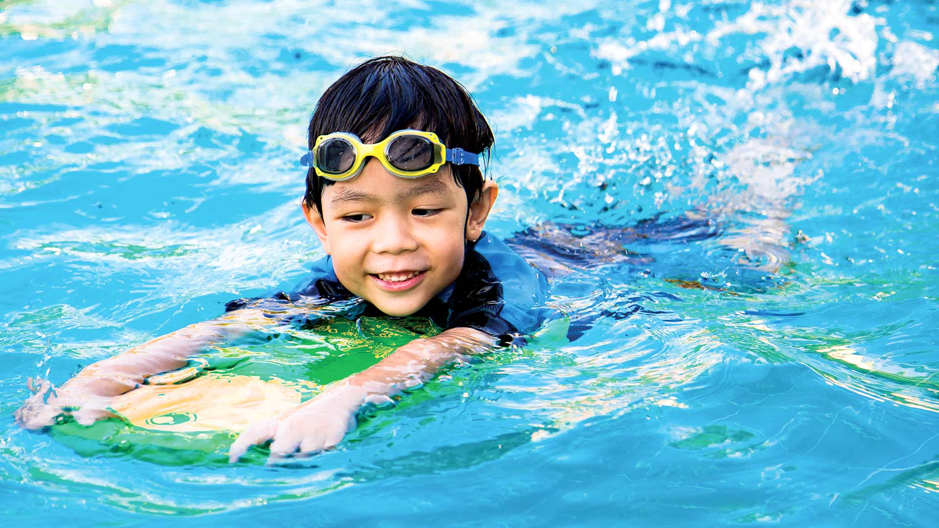 Asian child learning how to swim